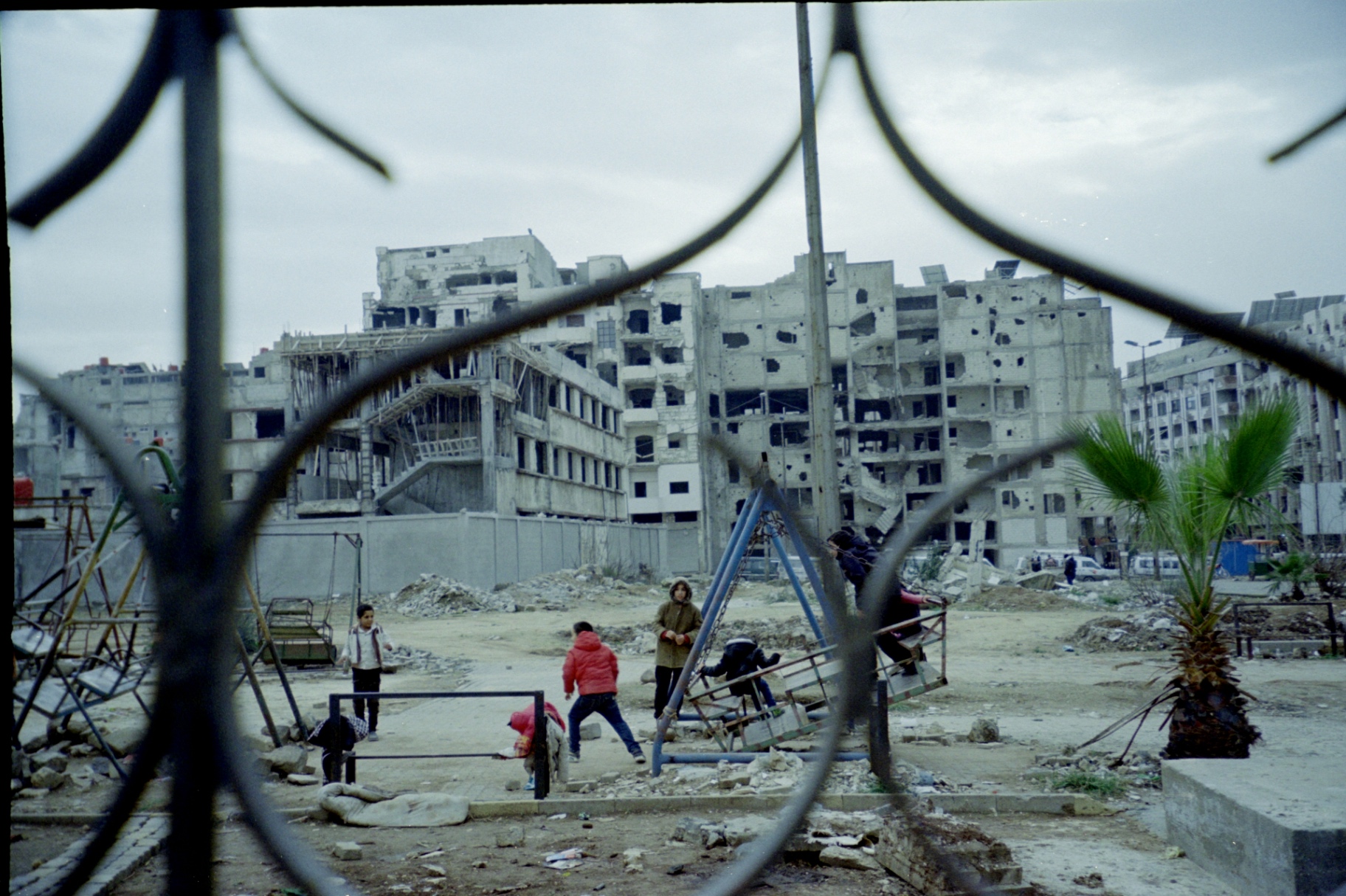 Children playing in a Homs neighborhood amid war-damaged buildings